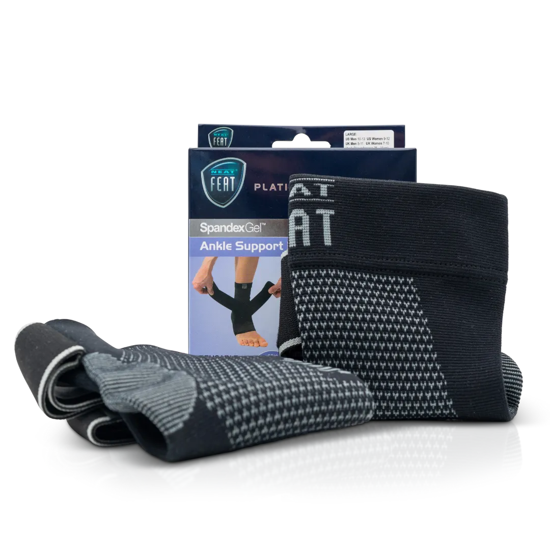 Platinum Series Spandex Gel Ankle Support Brace. The image shows the packaging box in the background, with two grey and black ankle braces displayed in the foreground. One brace is standing upright, while the other is lying down, showcasing the product's design and support features.