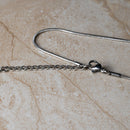 Close-up of a silver necklace chain from Magnetic Mobility's Birthstone collection, showcasing the detailed clasp and chain links. Designed for durability and comfort.